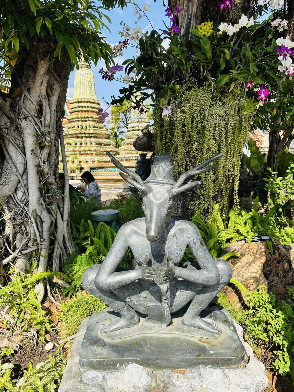 A stone hermit statue in the temple gardens
