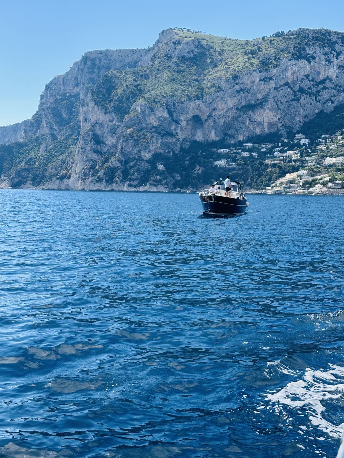 A boat cruising beneath the cliffs of Capri