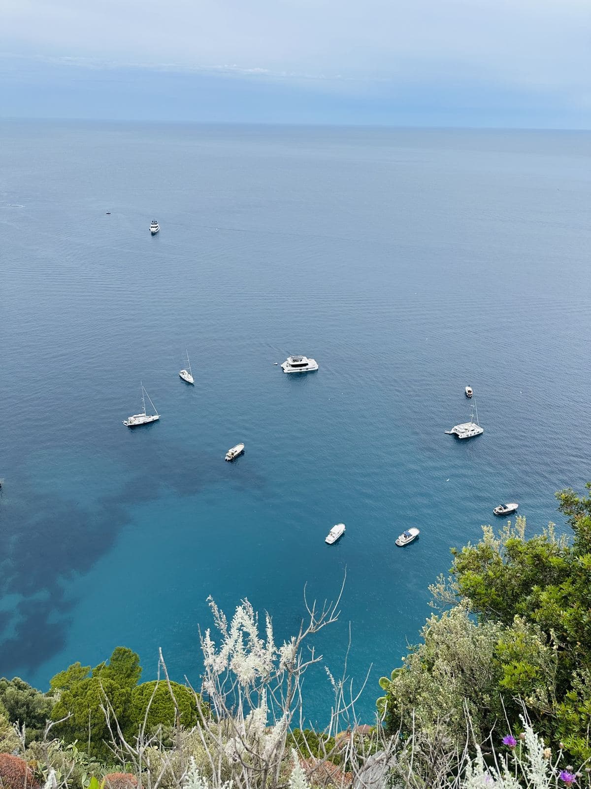 Yachts anchored in turquoise water far below