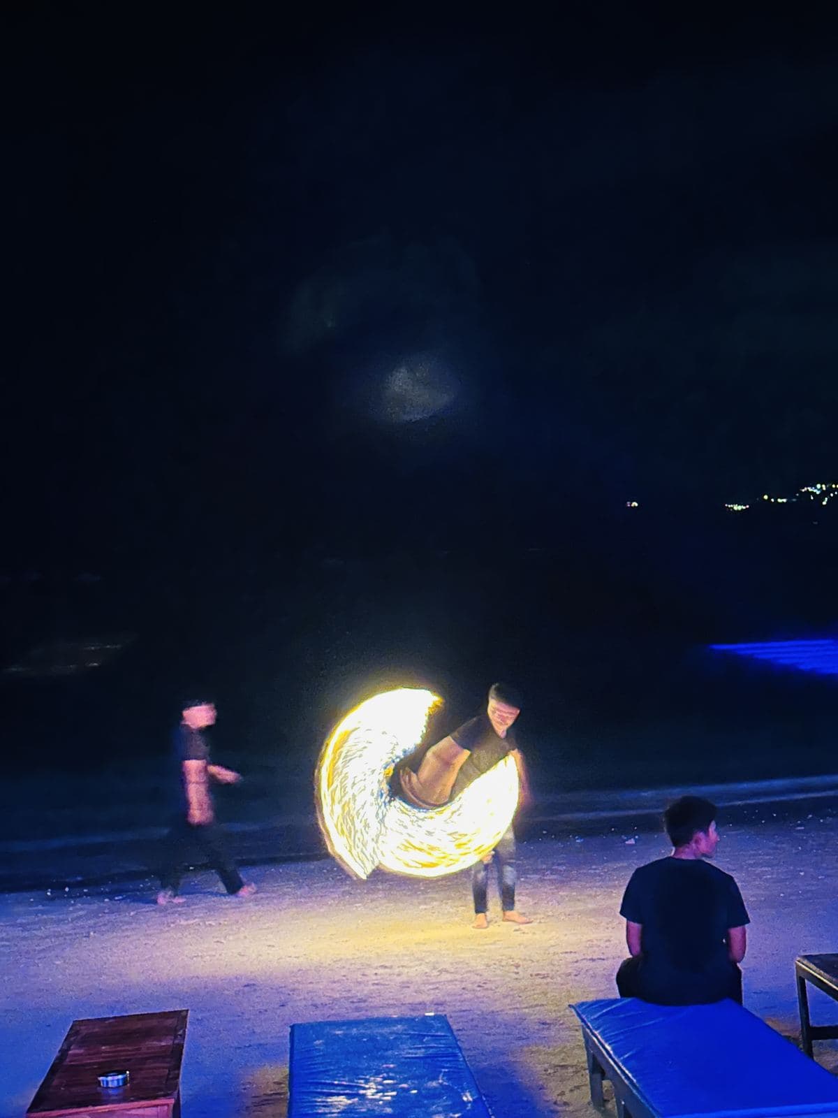 A fire dancer performing on the beach at night