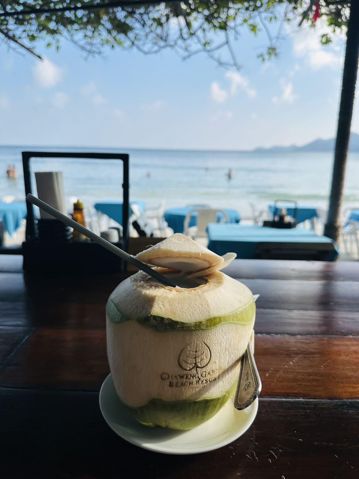 A fresh young coconut by the beach