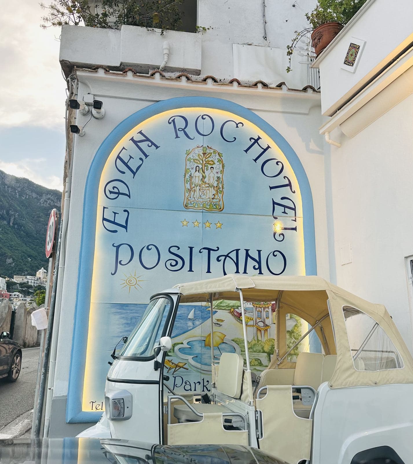 A hand-painted hotel sign and vintage Ape car
