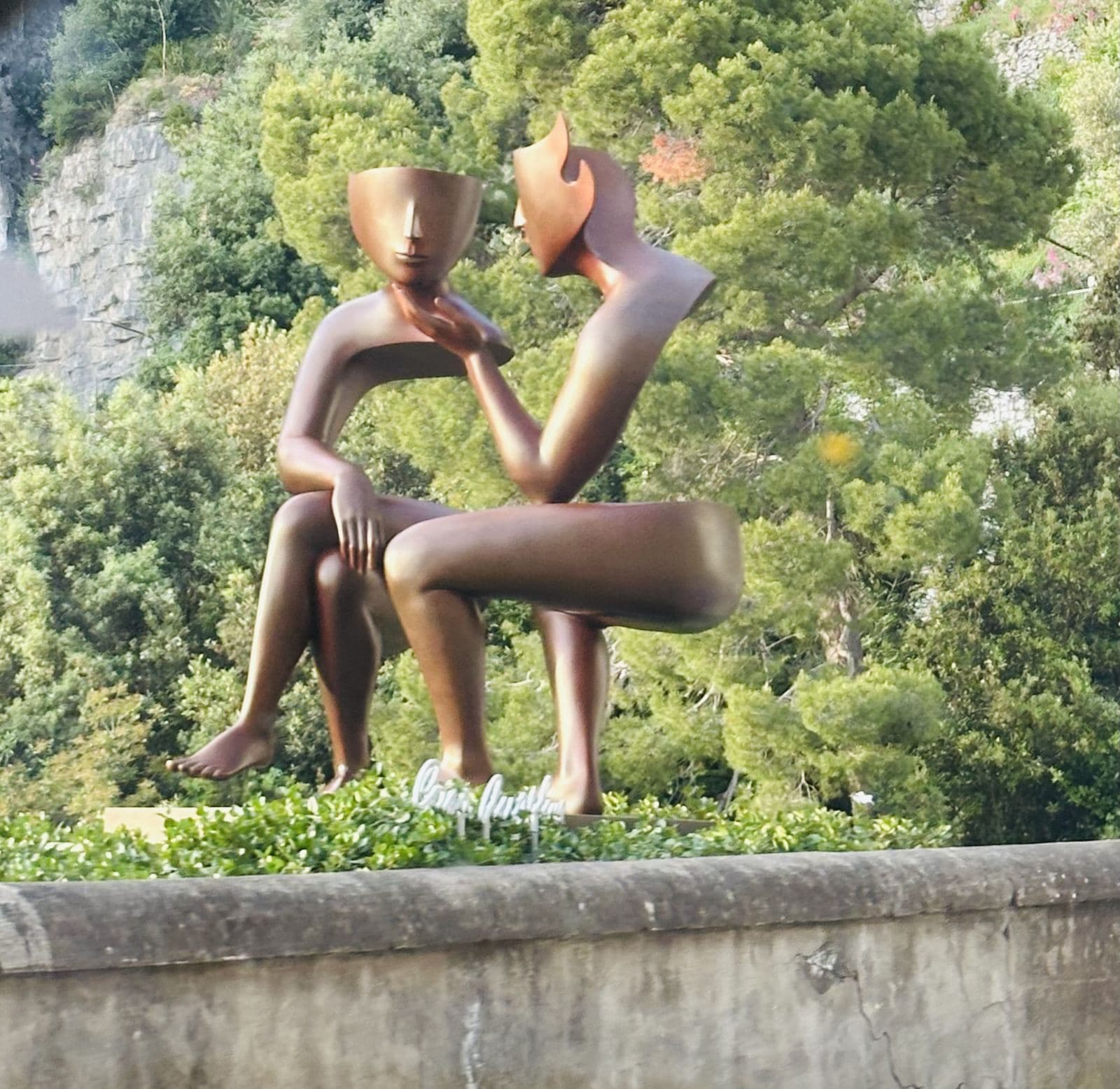 A modern bronze sculpture on a garden terrace